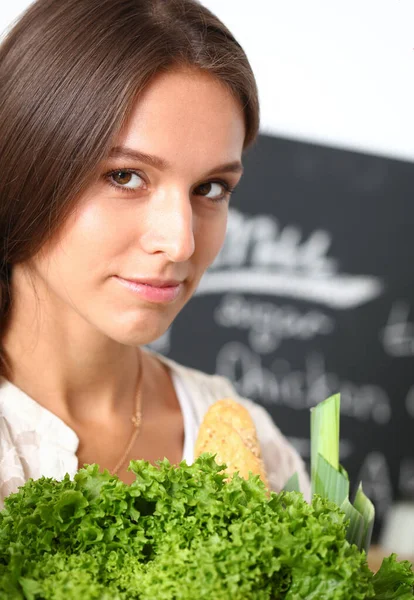 Lächelnde junge Frau mit Gemüse in der Küche. Lächelnde junge Frau — Stockfoto