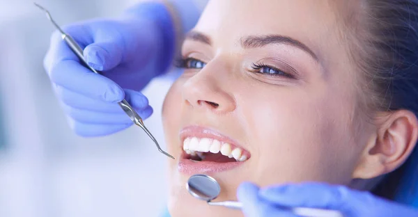 Mujer joven con la boca abierta examinando la inspección dental en el consultorio del dentista. — Foto de Stock