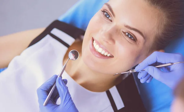 Joven paciente femenina con sonrisa bonita examinando la inspección dental en el consultorio del dentista. — Foto de Stock