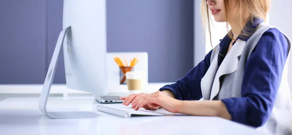 Молодая уверенная в себе деловая женщина, работающая за столом офиса и печатающая с ноутбуком — стоковое фото
