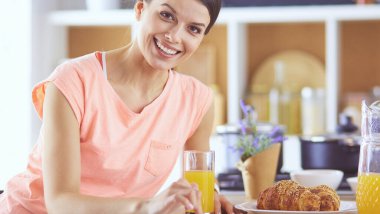 Mutfakta dijital tablet kullanan güzel genç bir kadın.