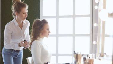 Makyöz, genç bir kadının profesyonel makyajını yapıyor.