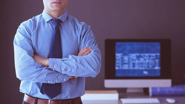 Uomo d'affari sorridente con touchpad in piedi sul posto di lavoro in ufficio — Foto Stock