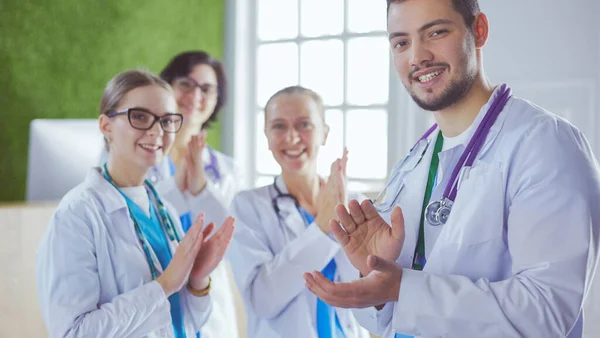 Happy medical team comprising male and female doctors smiling broadly and giving a thumbs up of success and hope — 스톡 사진