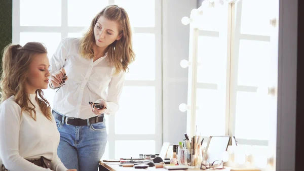 Make up artist facendo professionale make up di giovane donna — Foto Stock