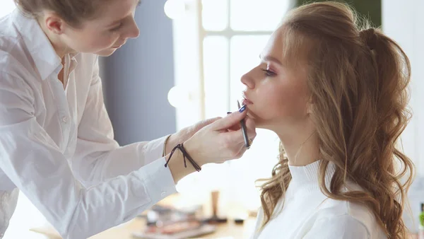 Beautiful young model woman getting fashion make-up — Stock Photo, Image