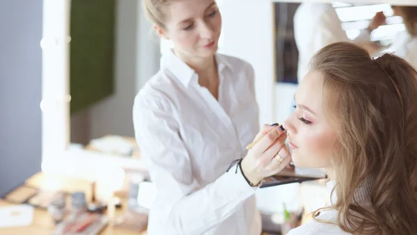 Hermosa joven modelo mujer consiguiendo maquillaje de moda — Foto de Stock