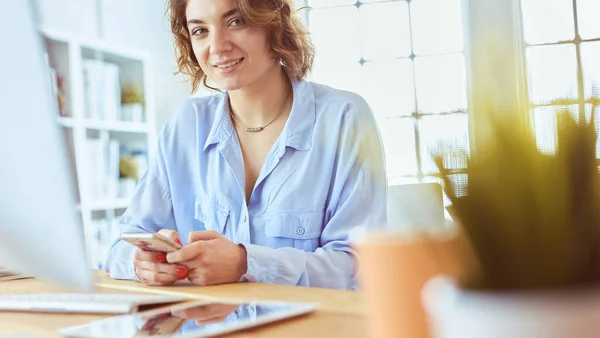 Mulher feliz trabalhando usando vários dispositivos em uma mesa em casa — Fotografia de Stock