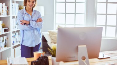 DSR fotoğraf makinesi olan gülümseyen genç bir kadının portresi çatı katında duruyor.