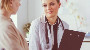 Doktor ve hasta masada otururken bir şey tartışıyorlar. İlaç ve sağlık hizmetleri kavramı