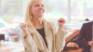 Genç güzel kadın yeni bir araba satın aldıktan sonra çok mutlu