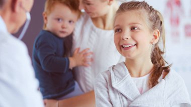 Steteskoplu kız ve doktor kalp atışlarını dinliyor.