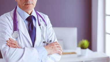 Parlak ofisinde gülümseyen bir doktorun portresi.