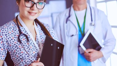 Bir doktor ekibi, kadın ve erkek, ofiste bekliyorlar.