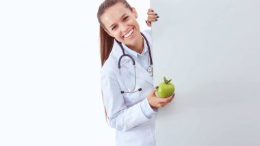 Elmalı ve boş pankartıyla gülümseyen doktor. Kadın doktorlar.