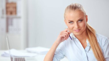 Ofis masasında dizüstü bilgisayar ve kulaklık kullanan gülümseyen resepsiyonistin portresi