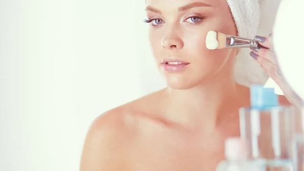 Фотографія молодої жінки, що наносить порошок для обличчя у ванній — стокове фото