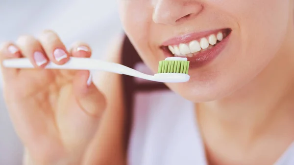 Junges hübsches Mädchen pflegt Mundhygiene mit Zahnbürste. — Stockfoto