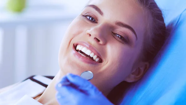 Mujer joven con la boca abierta examinando la inspección dental en el consultorio del dentista. — Foto de Stock