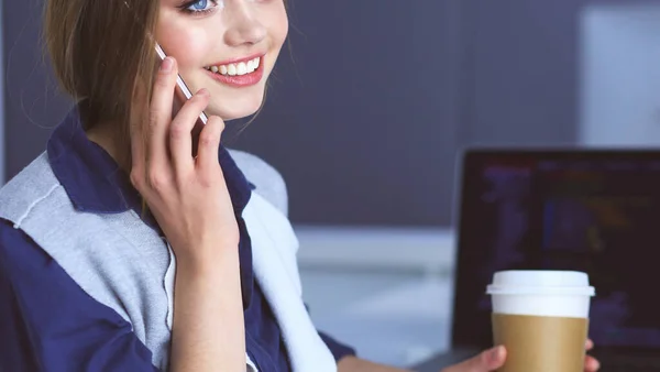 Jovem mulher feliz falando no telefone celular enquanto se senta com xícara de café — Fotografia de Stock