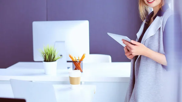 Junge Geschäftsfrau steht im Büro vor einem Tisch — Stockfoto