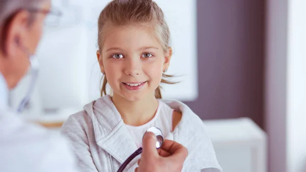 Menina e médico com estetoscópio ouvindo batimentos cardíacos — Fotografia de Stock