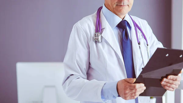 Male doctor writes notes on the clipboard in the hospital — Stock Photo, Image