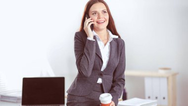 Modern ofiste telefonla konuşan başarılı, güzel bir kadın. Güzel, başarılı bir kadın.