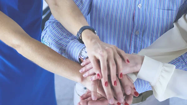 Compañeros de negocios apilando manos juntos en la oficina — Foto de Stock