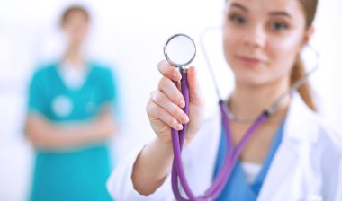 Steteskoplu kadın doktor dinliyor.