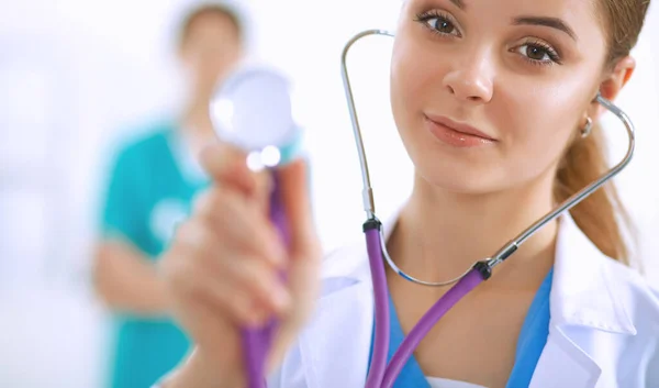 Mladá doktorka poslouchající stetoskop stojící v nemocnici — Stock fotografie