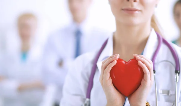 Female doctor with stethoscope holding heart — Stock Photo, Image