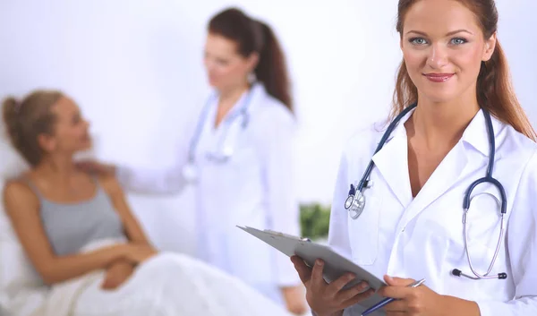 Femme médecin souriante avec un dossier en uniforme debout à hosp — Photo