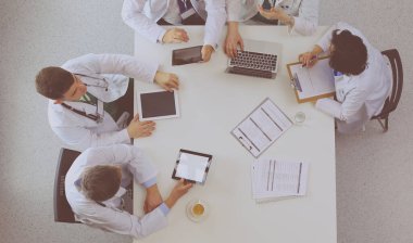 Tıbbi ekip masaya oturuyor ve tartışıyor.