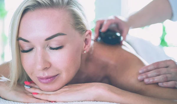 Giovane donna in salone spa, ottenere pietre massaggio — Foto Stock