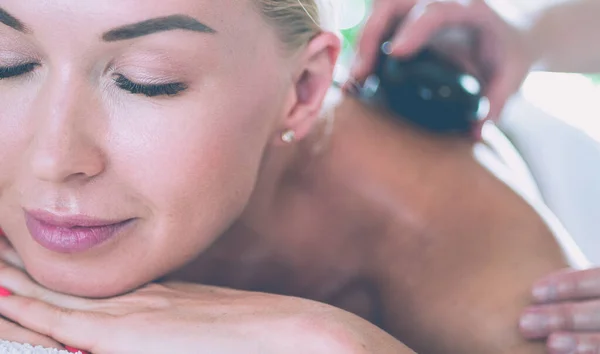 Giovane donna in salone spa, ottenere pietre massaggio — Foto Stock