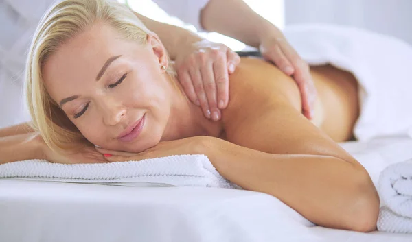 Ung kvinna njuter av massage i spa salong — Stockfoto