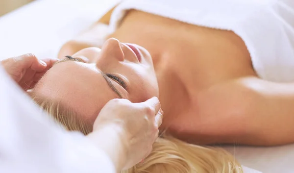 Mujer joven disfrutando de masajes en el salón de spa — Foto de Stock