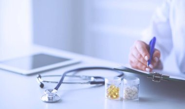 Steteskop cam masanın üzerinde duruyor. Yoğun bir doktor geçmişinde dizüstü bilgisayarı var. İlaç ya da eczane konsepti. Doktor çalışma masasında tıbbi aletler