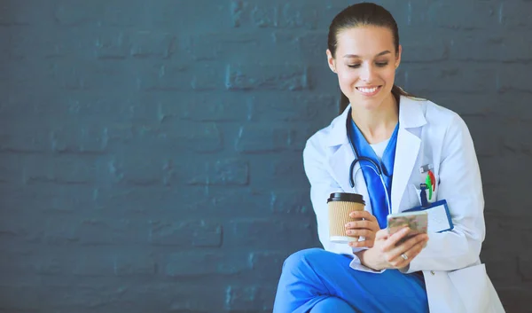 Een jonge vrouwelijke dokter die bij je telefoon zit. Vrouwelijke artsen. — Stockfoto