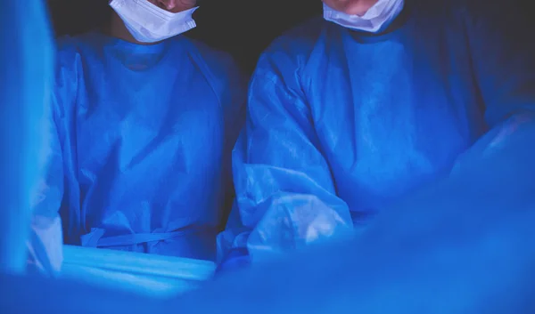 Imagen recortada del bisturí tomada médicos que realizan la cirugía. — Foto de Stock