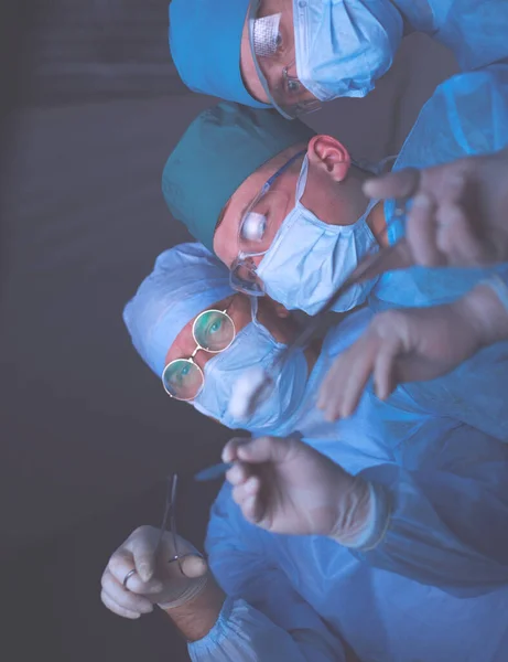 青を基調とした手術室で働く外科医のグループ。手術を行う医療チーム — ストック写真