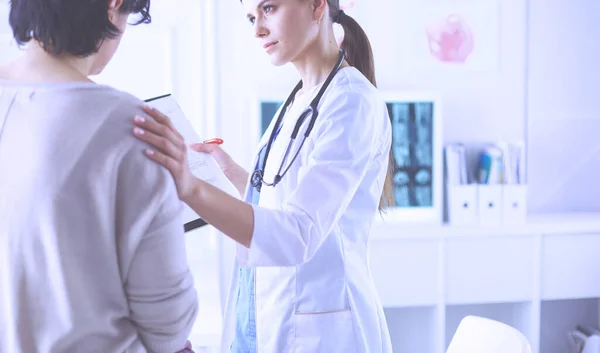 Schöne Ärztin erklärt einer Patientin die medizinische Behandlung — Stockfoto