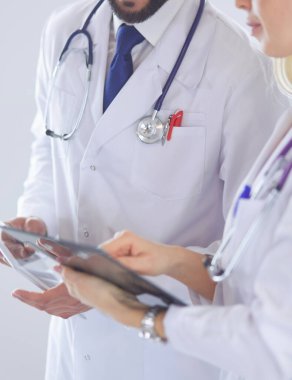 İki doktor bir dosya tutuyor ve hasta hakkında konuşuyorlar.