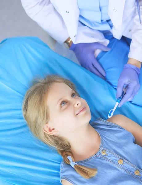 Kleines Mädchen sitzt in der Zahnarztpraxis. — Stockfoto