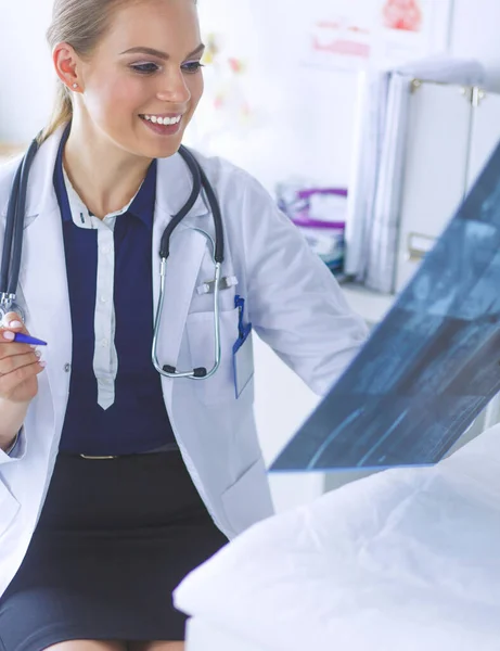 Joven atractiva doctora mirando la imagen de rayos X — Foto de Stock