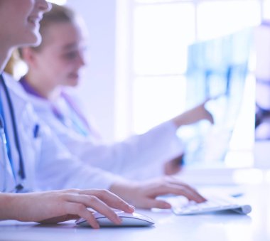 Hastanede bilgisayarla çalışan iki genç bayan doktor..