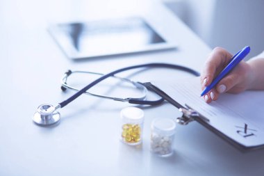 Steteskop cam masanın üzerinde duruyor. Yoğun bir doktor geçmişinde dizüstü bilgisayarı var. İlaç ya da eczane konsepti. Doktor çalışma masasında tıbbi aletler