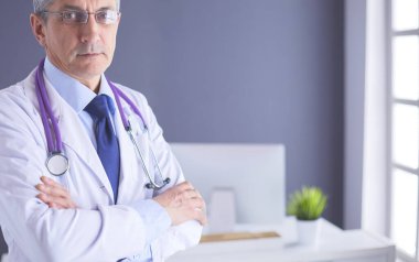 Parlak ofisinde gülümseyen bir doktorun portresi.