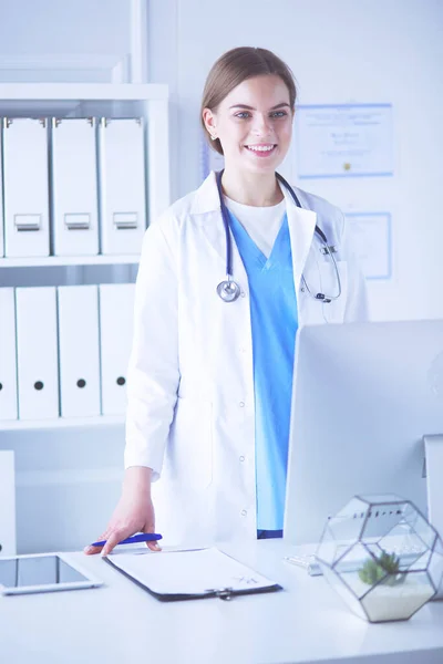 Jeune femme médecin au travail tout en pointant vers l'ordinateur dans le bureau de l'hôpital. — Photo